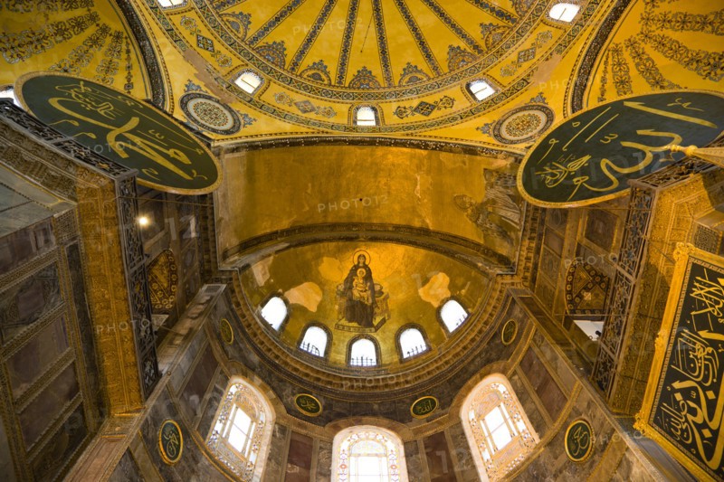 Turkey, Istanbul, Sultanahmet Haghia Sophia with apse mosaic of Theotokos or Virgin Mary enthroned holding the baby Jesus Christ below the dome and Arab Muslim texts on Calligraphic Roundels on the walls. 
Photo : Paul Seheult