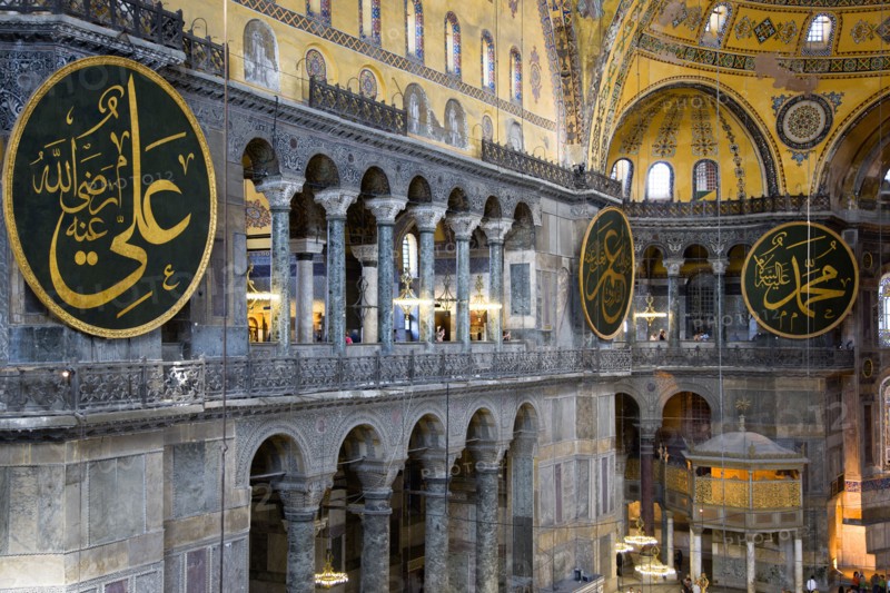 Turkey, Istanbul, Sultanahmet Haghia Sophia North Gallery beside the Nave with sightseeing tourists and Arab Muslim text on calligraphic roundels on the walls with the Lodge of The Sultan below. 
Photo : Paul Seheult