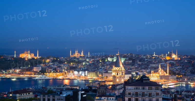 Turkey, Istanbul, View at sunset of illuminated city skyline from Beyoglu across rooftops to Galata Tower and Golden Horn with Galata Bridge leading to Sultanahmet with Haghia Sophia New Mosque and Blue Mosque with Sea of Marmara beyond. 
Photo : Paul Seheult