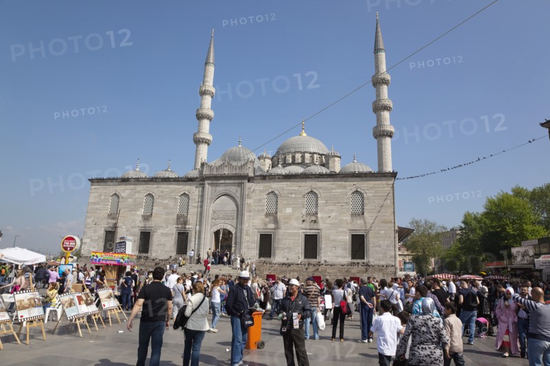 Turkey, Istanbul, Eminonu Yeni Camii New Mosque with people selling goods to the tourists in the square outside. 
Photo : Stephen Rafferty