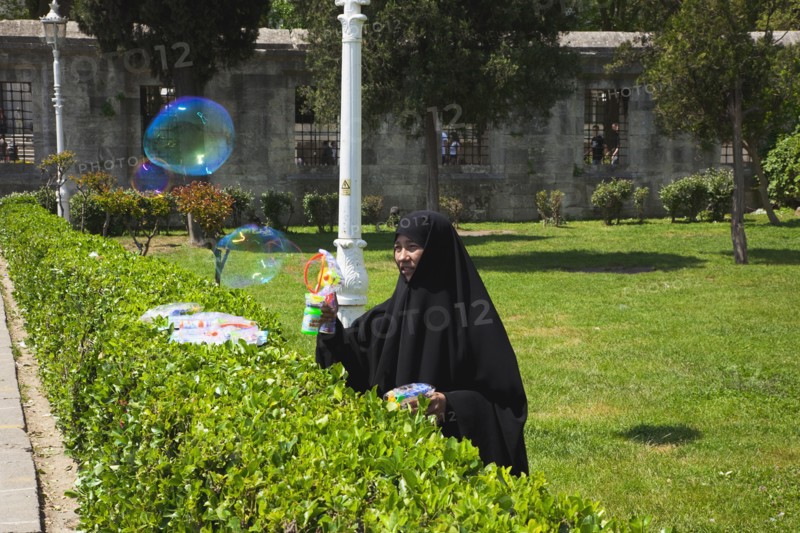 Turkey, Istanbul, Istanbul Sultanahmet woman selling bubble gun machine in park outside the Blue Mosque. 
Photo : Stephen Rafferty