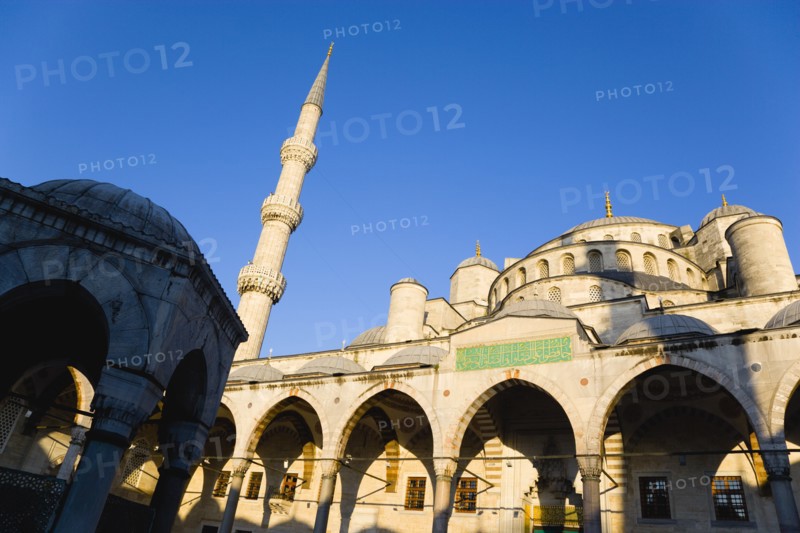 Turkey, Istanbul, Sultanahmet Camii The Blue Mosque domes seen from the Courtyard with Arabic text from the Koran in green and the Absolution Fountain in the foreground. 
Photo : Paul Seheult
