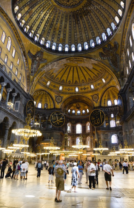Turkey, Istanbul, Sultanahmet Haghia Sophia Sightseeing tourists beneath the dome with murals and chandeliers in the Nave of the Cathedral. 
Photo : Paul Seheult