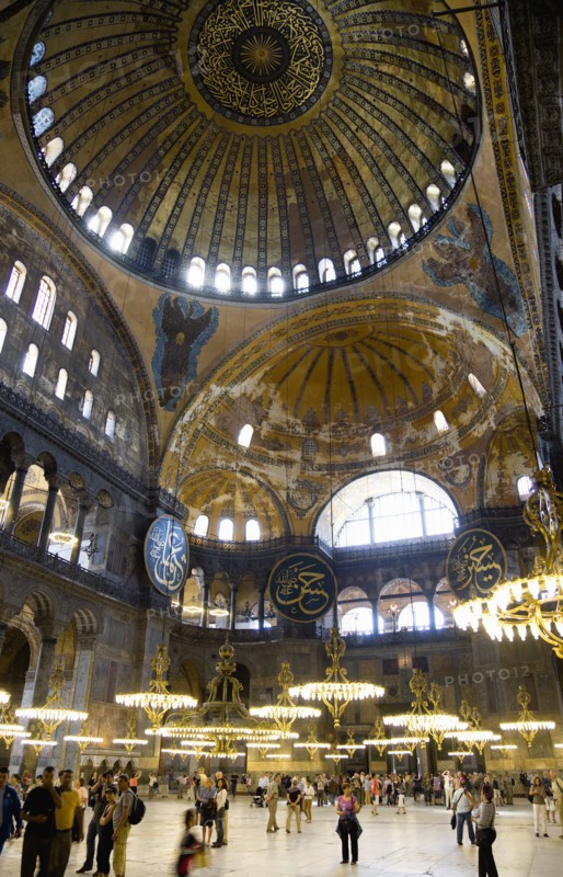 Turkey, Istanbul, Sultanahmet Haghia Sophia Sightseeing tourists beneath the dome with murals and chandeliers in the Nave of the Cathedral. 
Photo : Paul Seheult