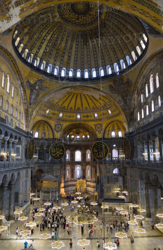 Turkey, Istanbul, Sultanahmet Haghia Sophia Sightseeing tourists beneath the dome with murals and chandeliers in the Nave of the Cathedral. 
Photo : Paul Seheult