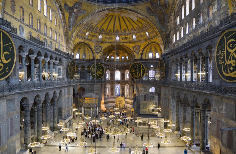 Turkey, Istanbul, Sultanahmet Haghia Sophia Sighseeing tourists beneath the dome with murals and chandeliers in the Nave of the Cathedral. 
Photo : Paul Seheult