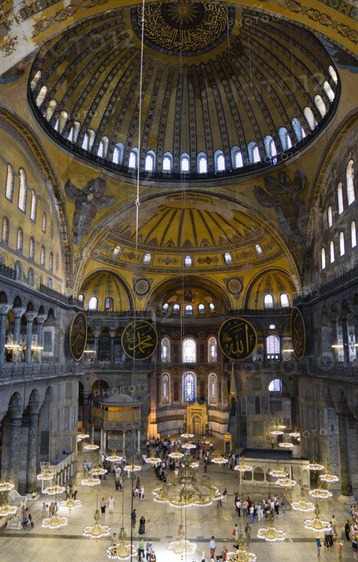 Turkey, Istanbul, Sultanahmet Haghia Sophia Sightseeing tourists beneath the dome with murals and chandeliers in the Nave of the Cathedral. 
Photo : Paul Seheult