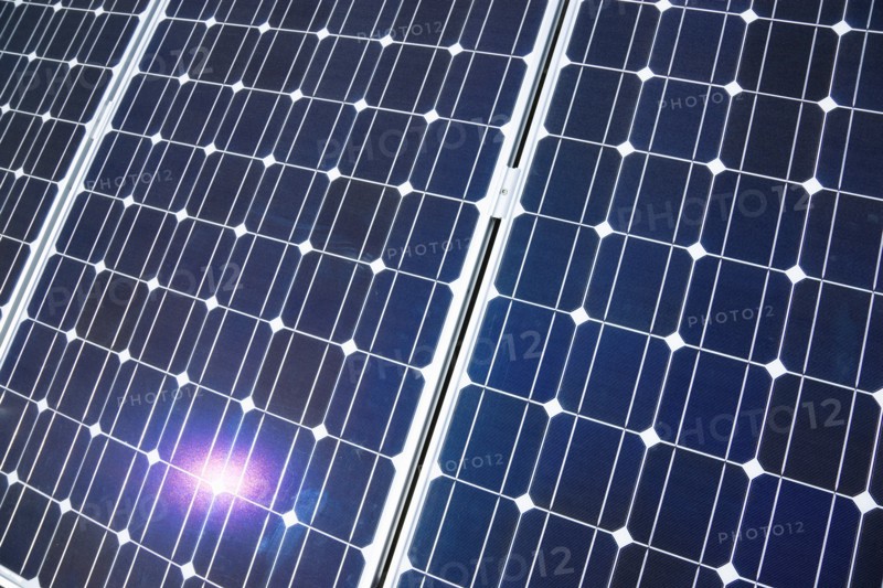 Architecture, Environment, Solar Panels, Alternative Energy Electricity Solar photovoltaic roof panels on detached house for electricity conversion with the sun reflected in a panel. 
Photo : Paul Seheult