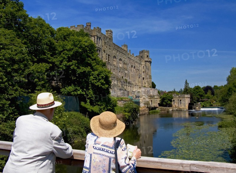 England, Warwickshire, Wawick Castle, Couple looking at castle from bridge over the river Avon. 
Photo : Chris Penn