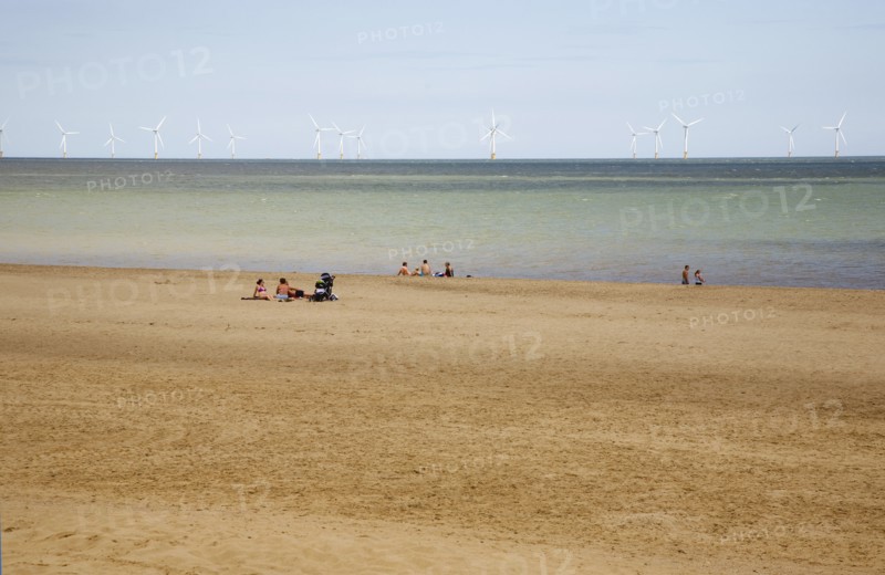 Wind Farm offshore on the horizon showing turbine blades.