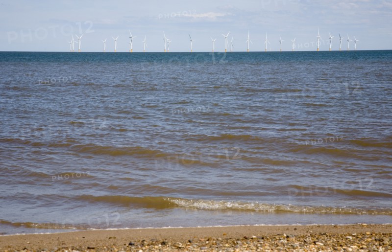 Wind Farm offshore on the horizon showing turbine blades.