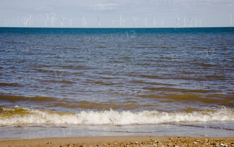 Wind Farm offshore on the horizon showing turbine blades.