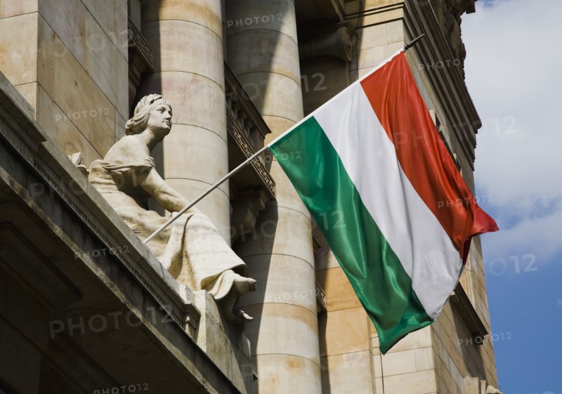 Hungarian Flag flying with Art Nouveau facade behind in central Pest.