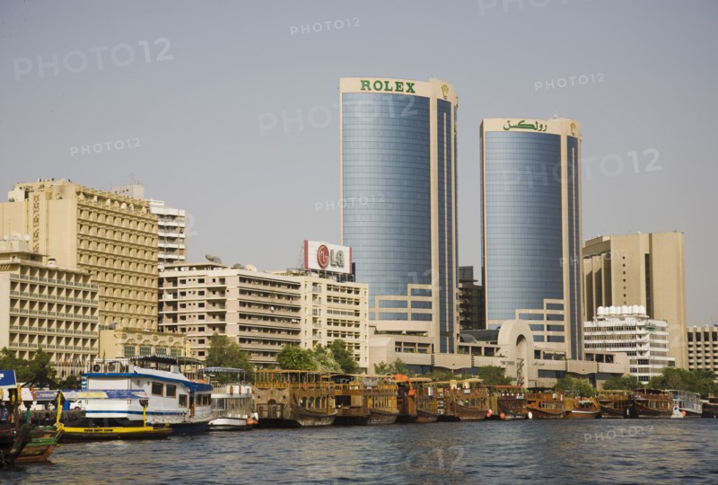 Creek with Twin Towers shopping mall and skyline behind.