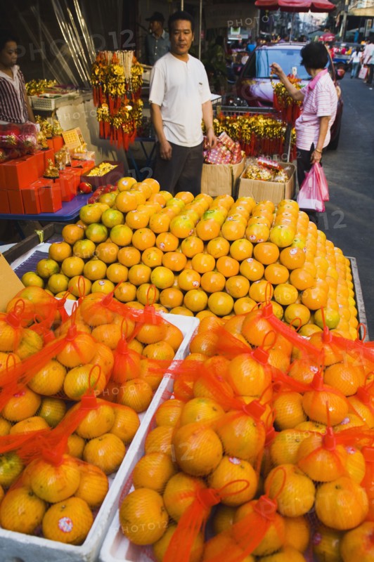 Stallholder attending oranges on stall for Chinese New Year.