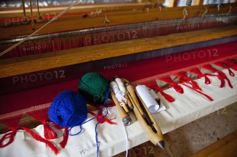 Close of an old traditional loom with balls of wool and tools.
