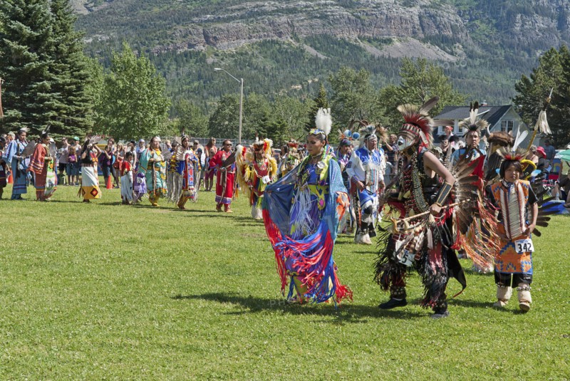 Grand Entry of dancers in full regalia at the Blackfoot Arts & Heritage Festival Pow Wow organized by Parks Canada and the Blackfoot Canadian Cultural Society at this UNESCO World Heritage Site Mount Vimy in the background