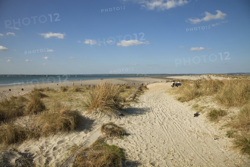 West Wittering Beach View across sand dunes towards beach and sea at East Head. Sunshine and blue sky.
