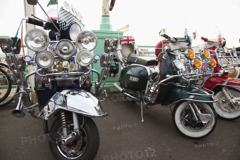 Elaborately decorated Mopeds on Madeira Drive during motorbike festival.