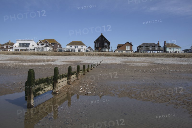 Seafront houses from beach with groyne in foreground.