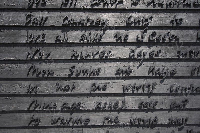 Detail of building gable wall with words carved from wood.