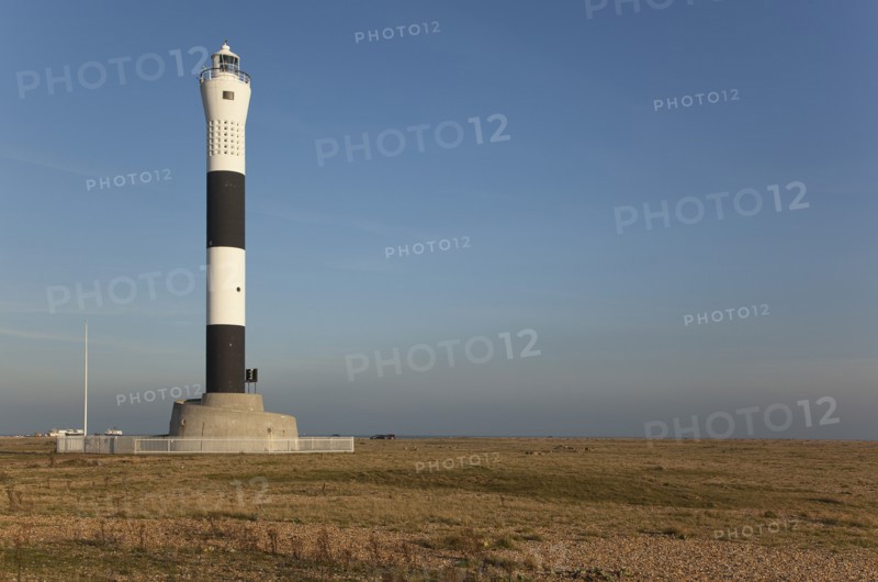 Black and white painted lighthouse on the shingle beach.