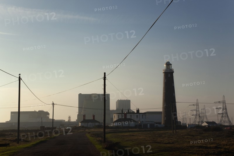 Silhouetted Nuclear power station and lighthouse.