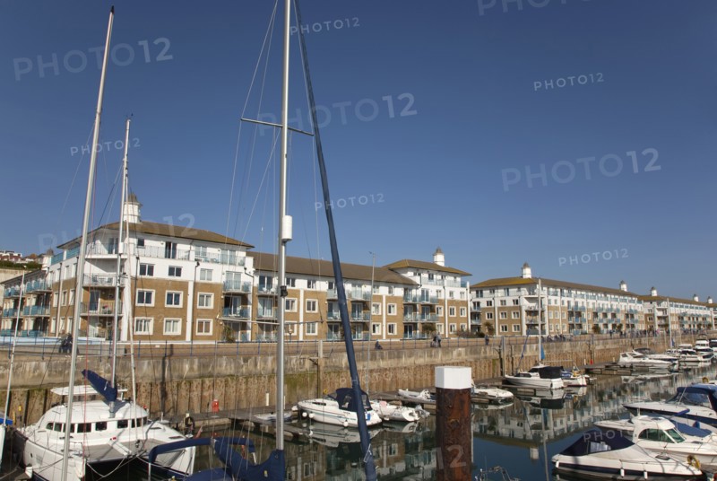 View over boats moored in the Marina with apartment buildings behind.