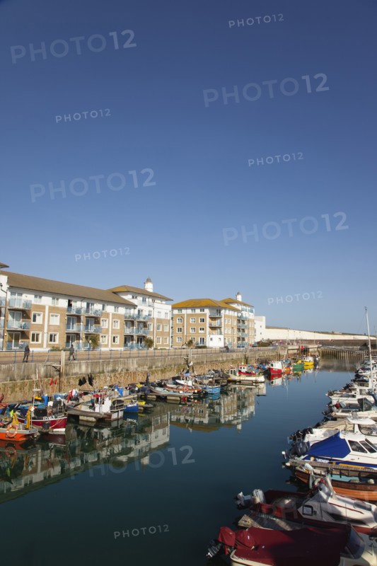 View over boats moored in the Marina with apartment buildings behind.