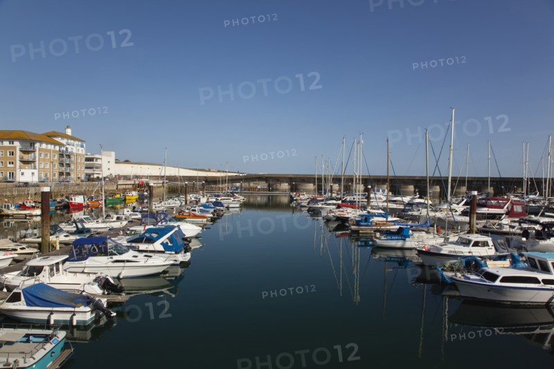View over boats moored in the Marina with apartment buildings behind.