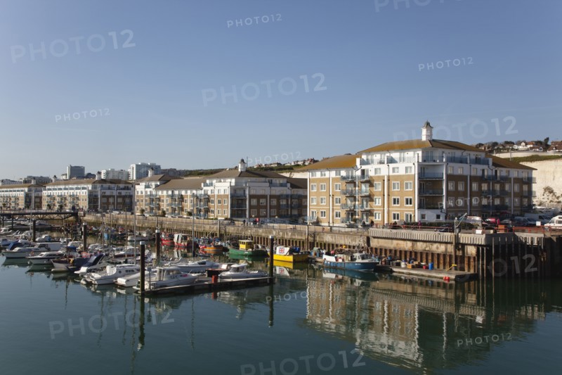 View over boats moored in the Marina with apartment buildings behind.