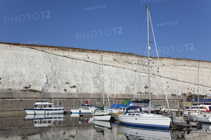 Boats moored in the Marina with chalk cliffs behind.