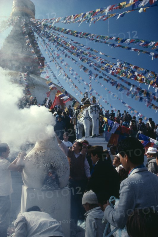 Nepal, Boudhanath, Burning pine bough incense during New Year or Los Har. Photo : Jon Burbank