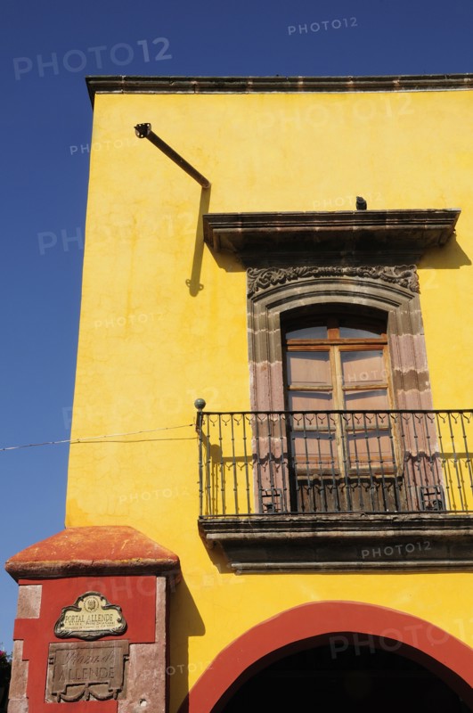 Mexico, Bajio, San Miguel de Allende, El Jardin Part view of yellow painted exterior facade of building with French windows and balcony. Photo : Nick Bonetti