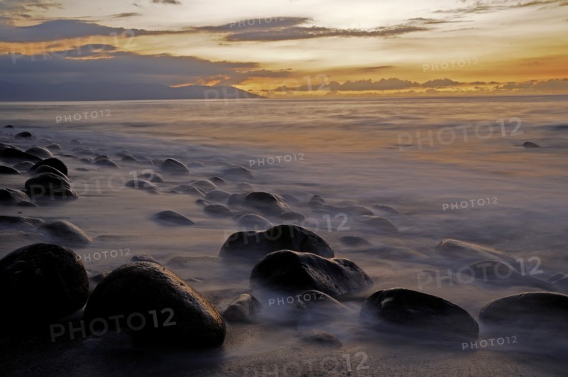 Mexico, Jalisco, Puerto Vallarta, Waves and rocks on beach at sunset. Photo : Nick Bonetti