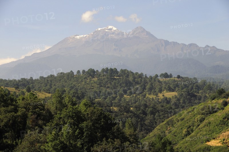 Mexico, Puebla, View of Ixtaccihuatl volcano with wooded parkland in foreground. Photo : Nick Bonetti