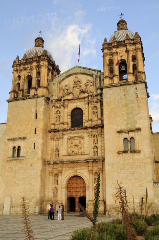 Mexico, Oaxaca, Church of Santo Domingo exterior facade and bell towers with small group of people standing outside entrance. Photo : Nick Bonetti