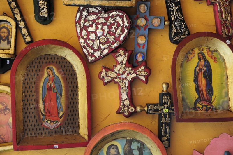 Mexico, Michoacan, Patzcuaro, Religious kitsch art displayed on yellow painted wall. Photo : Nick Bonetti
