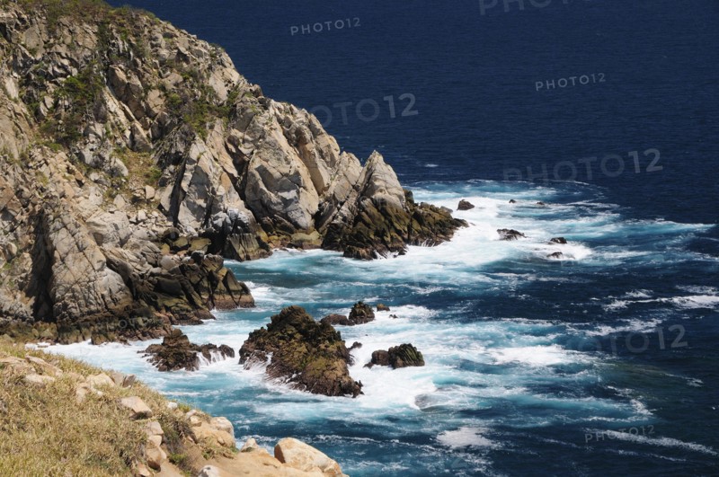 Mexico, Oaxaca, Huatulco, Waves breaking against rocky coastline.. Photo : Nick Bonetti