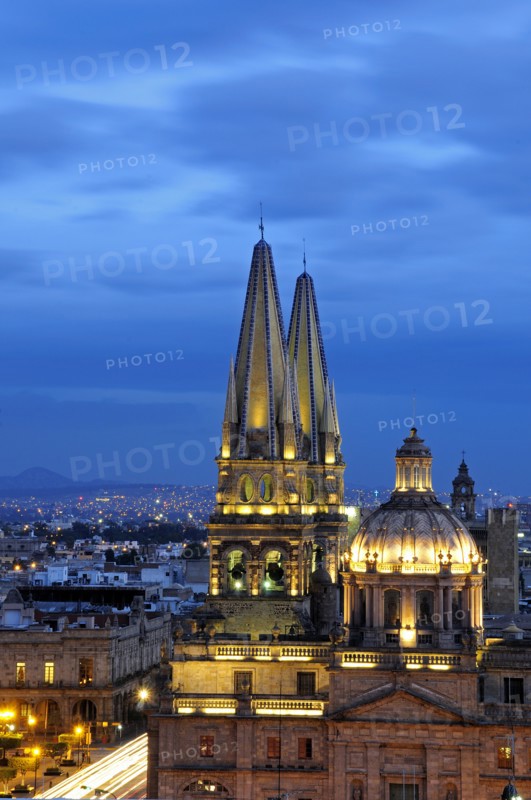 Mexico, Jalisco, Guadalajara, Cathedral domed roof and bell towers at night with city spread out behind. Photo : Nick Bonetti