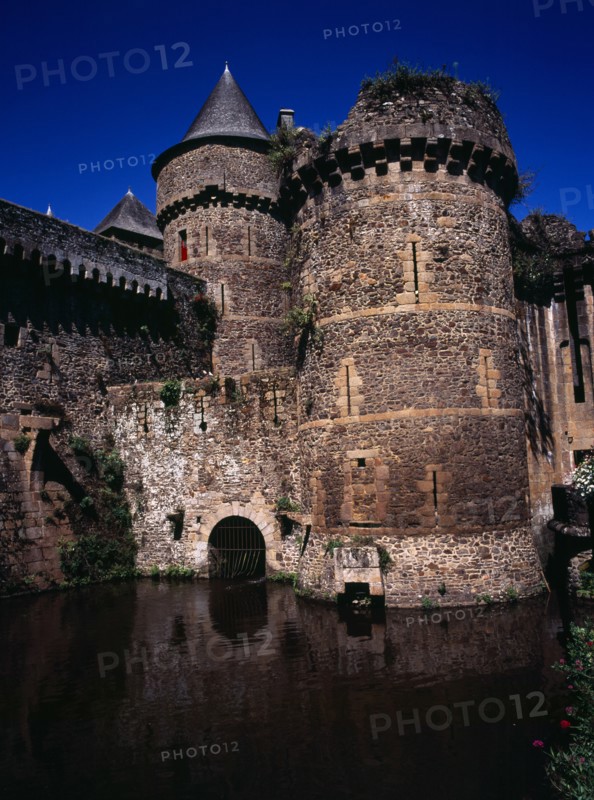France, Bretagne, Ille-et-Vilaine, Fougeres. Defensive walls and towers of the chateau dating from 11th to 15th century rising from moat. Photo : Bryan Pickering