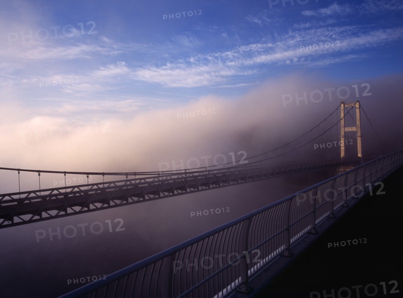 France, Bretagne, Finistere, Ile de Crozon. View of the old bridge to Crozon over the River Aulne from the new Pont de Terenez suspension bridge completed in 2011 in fog.. Photo : Bryan Pickering