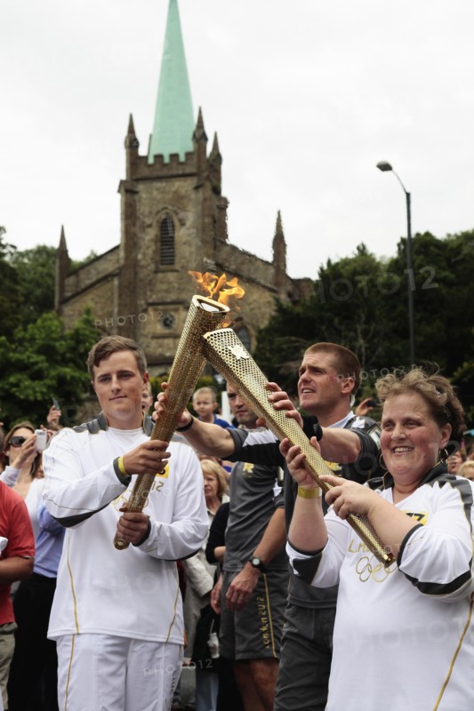 England, Kent, Tunbridge Wells, Olympic Torch relay runners handing over torch by exchanging the flame. Photo : Sean Aidan