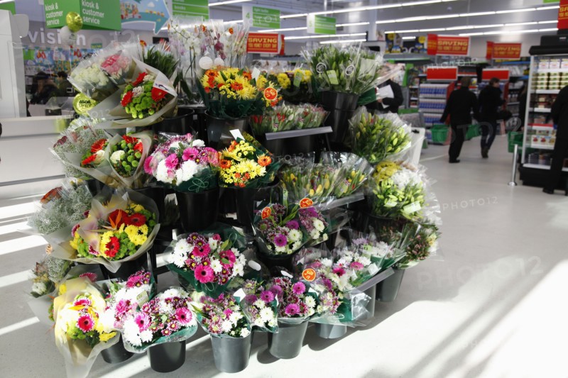 England, Shopping, Supermarket, Bunches of fresh flowers for sale by entrance. Photo : Sean Aidan