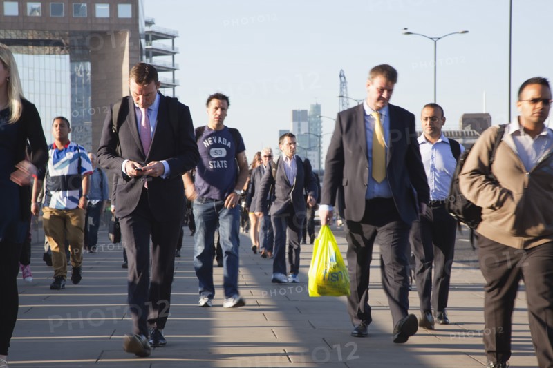 England, London, Early morning commuters crossing London Bridge towards the City Financial district. Photo : Stephen Rafferty