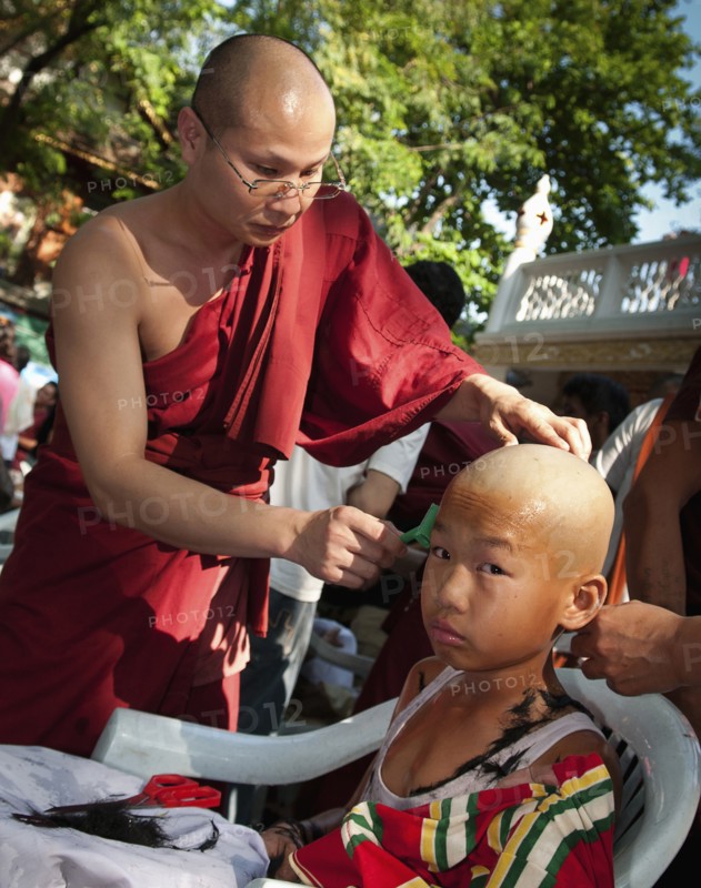 Thailand, Chiang Mai, Shaving of hair is part of the ritual of Poi Sang Long. This is the ordination ceremony for Shan boys to become novice Buddhist monks in Thailand. It is expected that every male will ordain as a monk at least once in his life. The entire ceremony last 3-4 days and relates directly to the life story of the Buddha who was once a prince in northern India and rejected his privileged royal lifestyle in favour of a humble existence seeking only inner enlightenment. After their heads are shaved the boys become crystal sons dressed only in white. This is followed by a period of 3 days when they dress elaborately and lavishly like the princes of old India. During that time they are pandered and catered to in the style of a prince. They are even carried about on the shoulders of family or friends so that their feet do not touch the ground. 
Photo Martin F. Johnston / Eye Ubiquitous