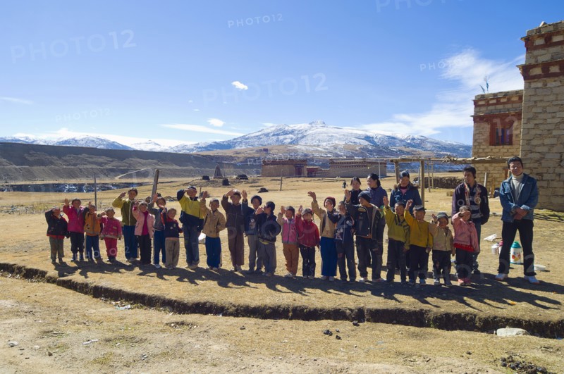 China, Szechuan Province, Tibet, School children waving outside their school. 
Photo Nic I Anson / Eye Ubiquitous