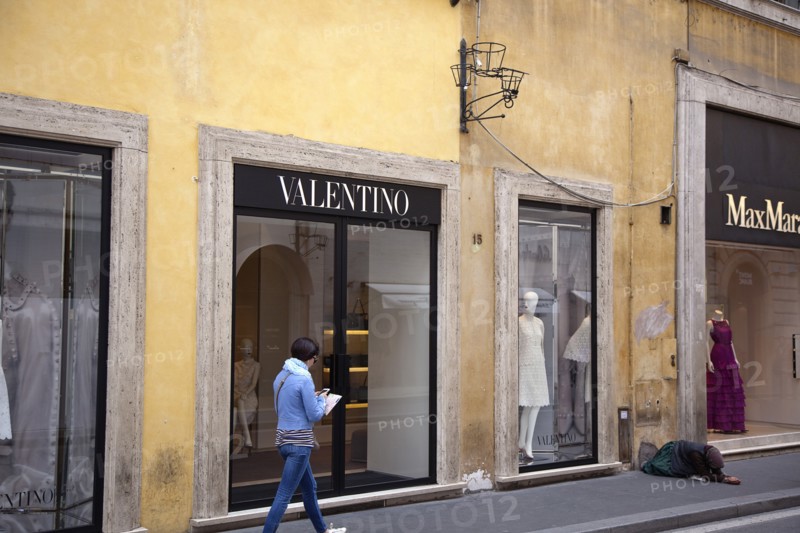 Italy, Lazio, Rome, Via del Condotti Exterior of the Valentino designer clothing shop with woman begging outside. . 
Photo Stephen Rafferty / Eye Ubiquitous