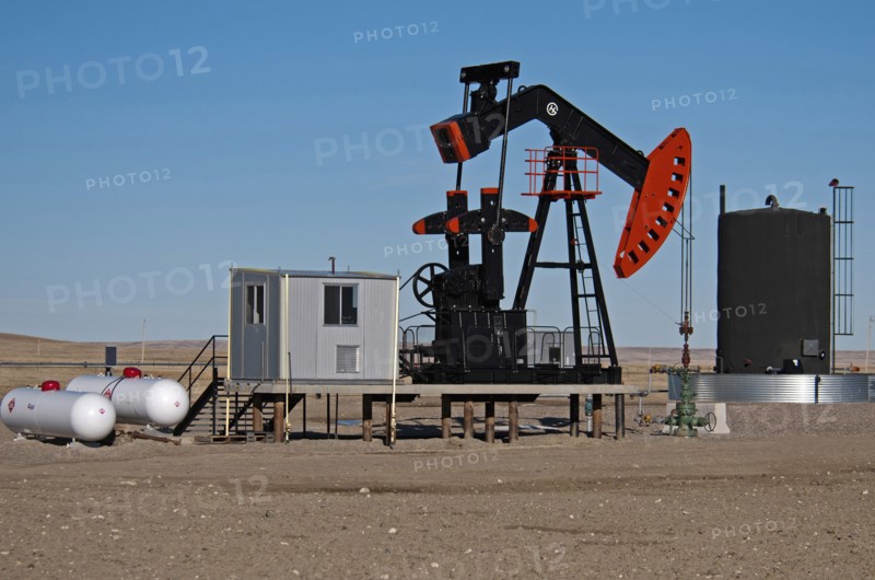 Canada, Alberta, Milk River Ridge, Oil pump jack or nodding donkey and storage tank on the edge of the Bakken Play near the Montana, USA border. 
Photo Trevor Page