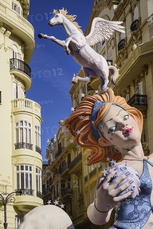 Spain, Valencia Province, Valencia, Female Papier Mache figure with a horse on her head in the street during Las Fallas festival. 
Photo Hugh Rooney